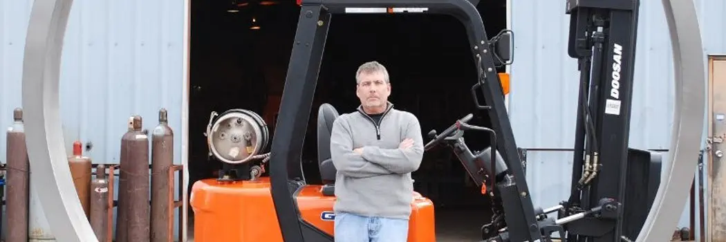 A man beside a Doosan CNC equipment